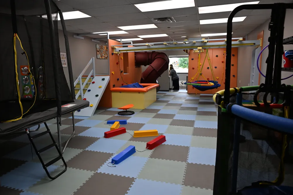 The length of the sensory gym: trampoline, balance beams, climbing wall, slide, and a swing